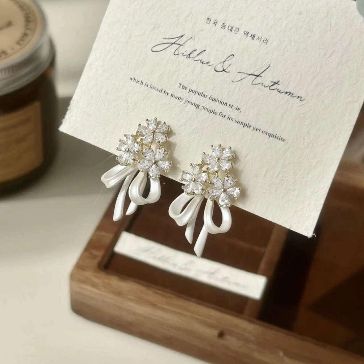 Holding a flower ribbon bow zircon earrings