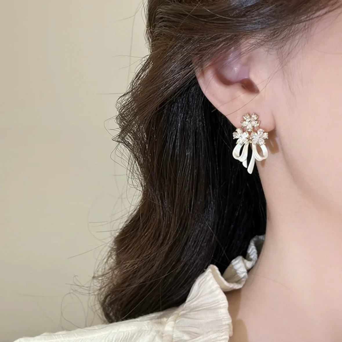 Holding a flower ribbon bow zircon earrings