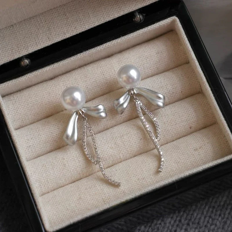 Holding a flower ribbon bow zircon earrings