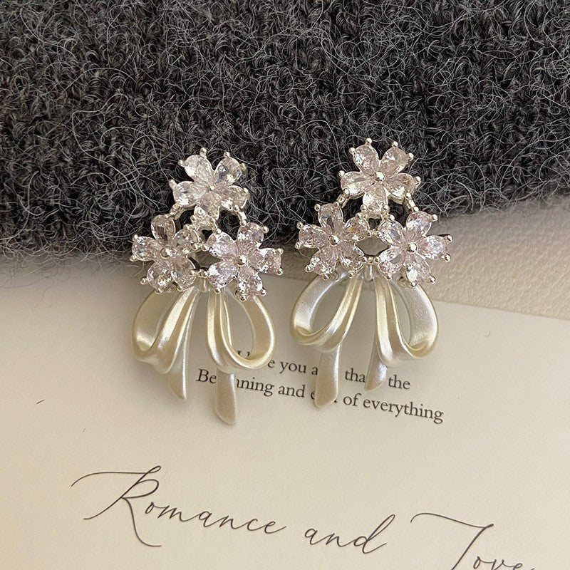 Holding a flower ribbon bow zircon earrings