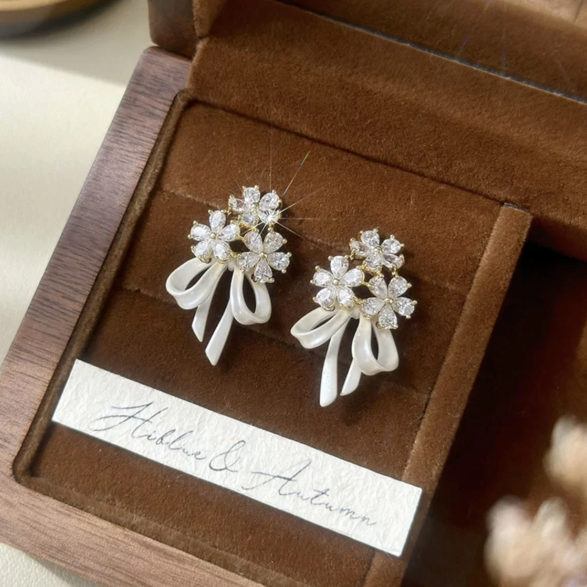 Holding a flower ribbon bow zircon earrings