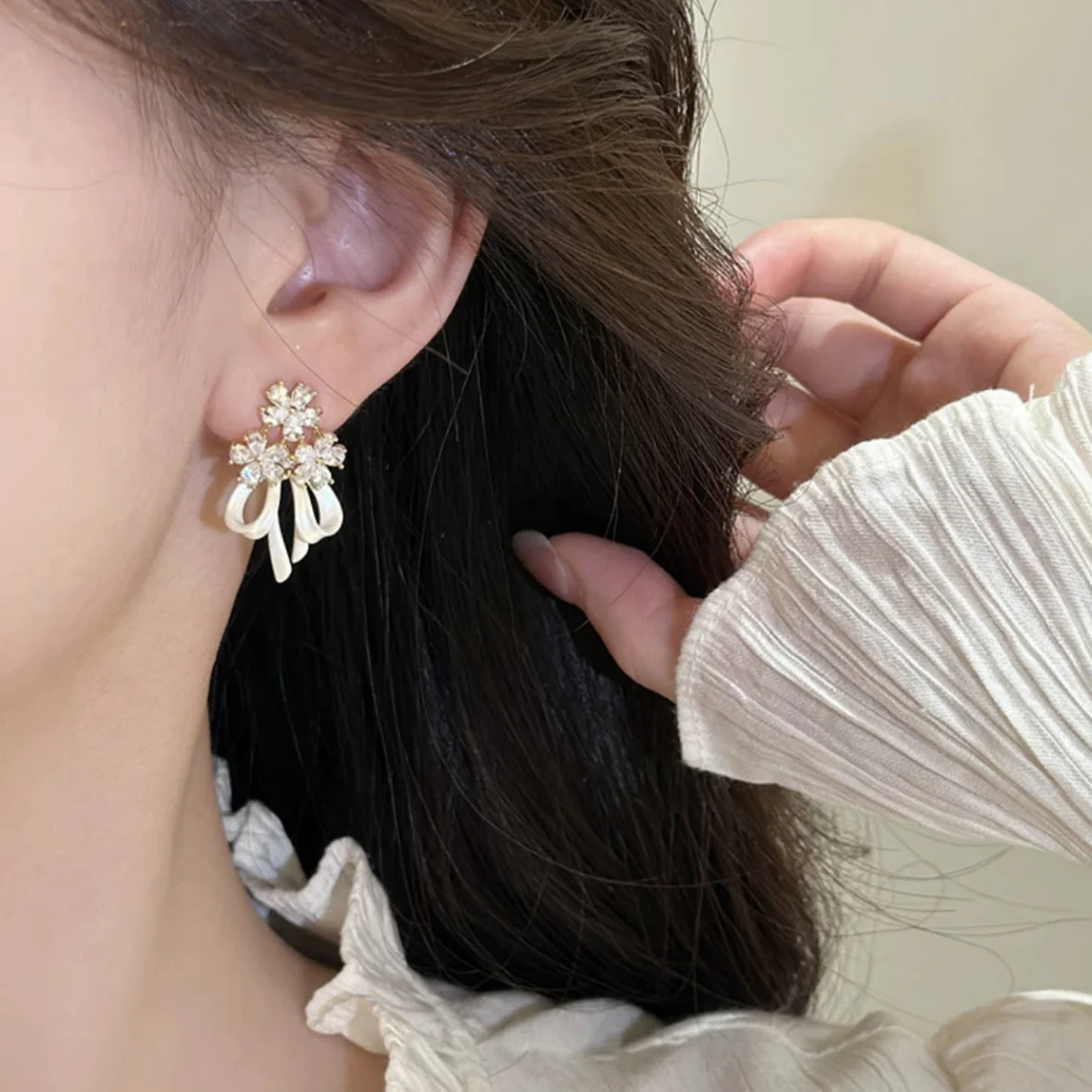 Holding a flower ribbon bow zircon earrings