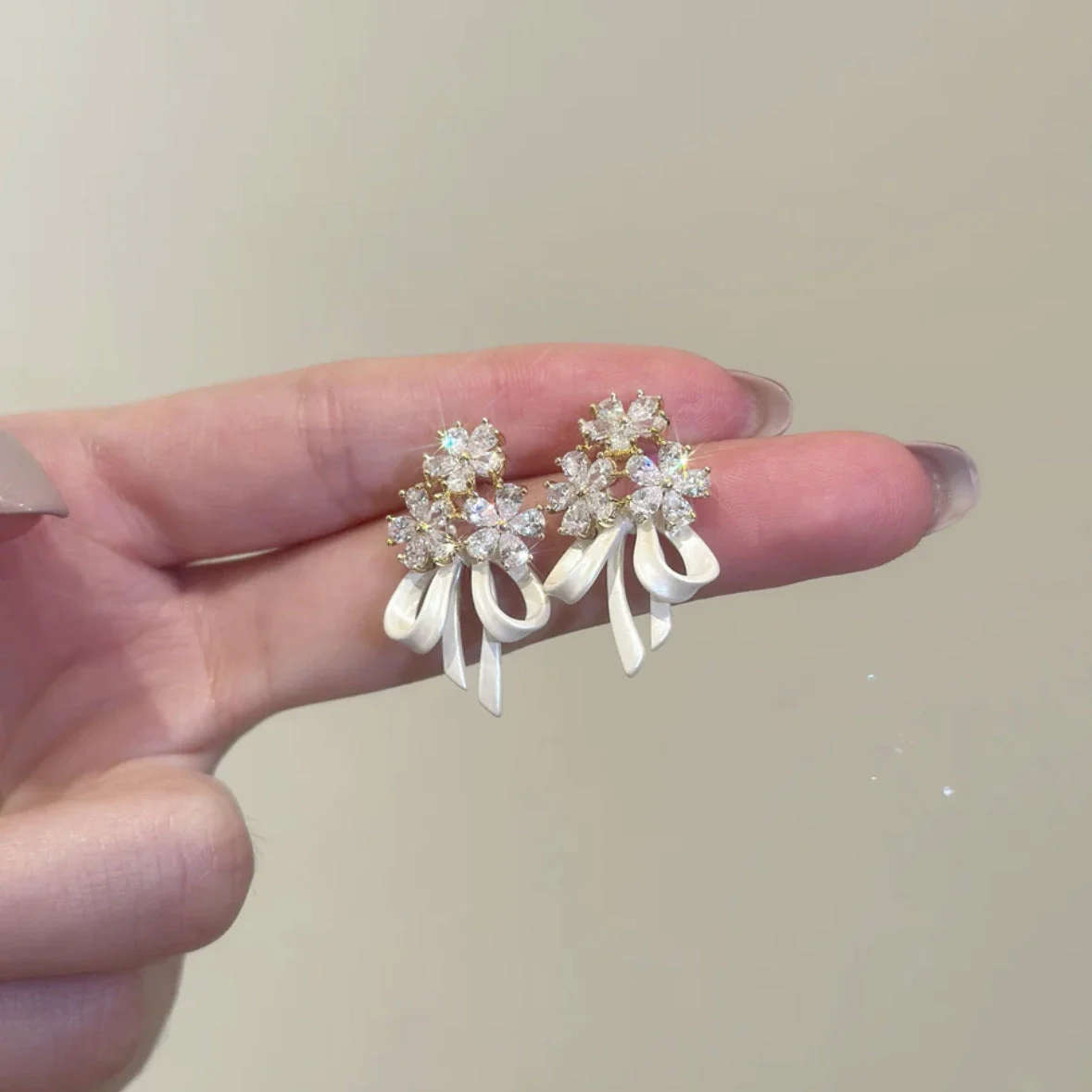 Holding a flower ribbon bow zircon earrings